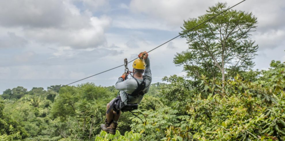 Nepal travel deals close up shot man hanging sliding zipline beautiful park cloudy sky